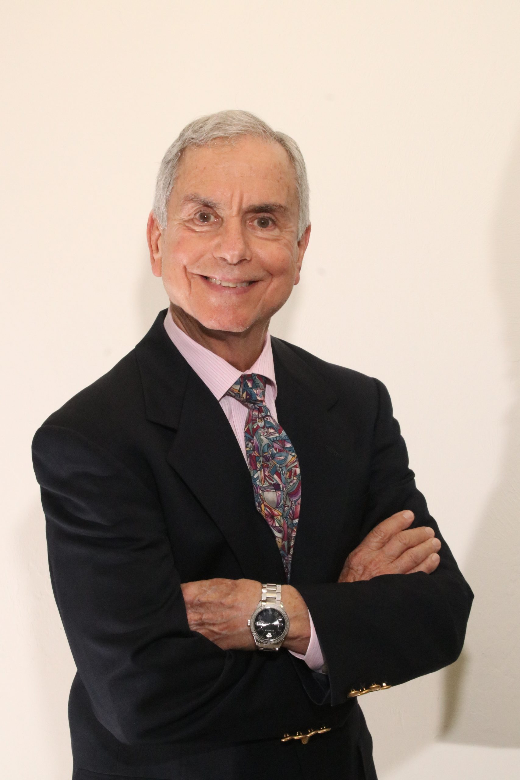 A man in a suit and tie with his arms crossed.