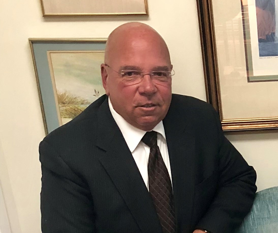 A man in a suit and tie sitting down.